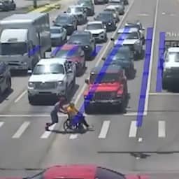 Video | Man in Spider-Man-pak helpt oudere in rolstoel druk kruispunt over