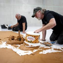 Museumbezoekers stappen in de Pindakaasvloer van Wim T. Schippers