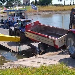 Video | Volgeladen aanhanger van tractor in water beland bij pont in Doornenburg