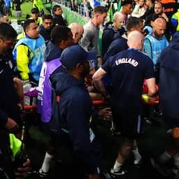 Jordan Henderson op brancard van veld na val over boarding bij Engels feestje
